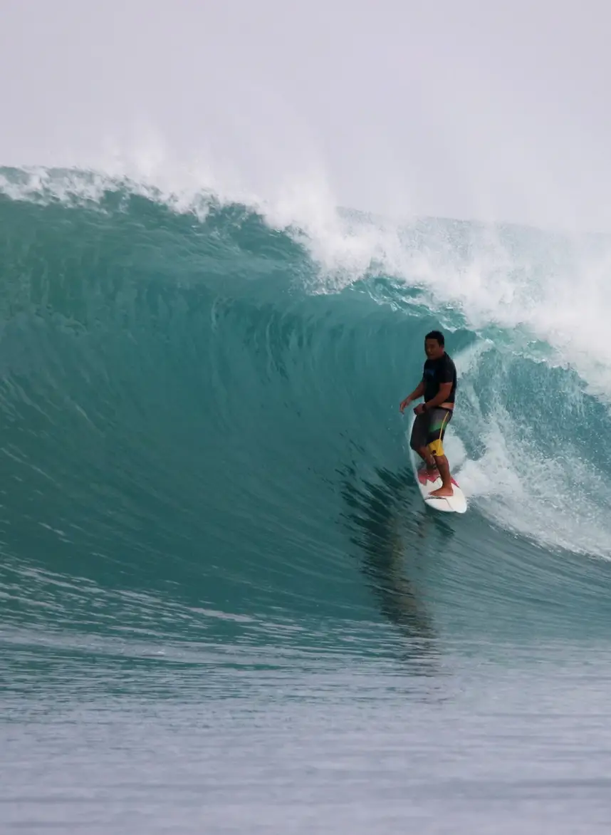 Justin Buu’lolo riding down the face of a large green wave